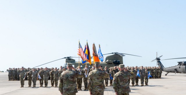 U.S. Army Lt. Gen. Charles Costanza, V Corps commanding general, salutes the unit colors alongside outgoing and incoming leadership of 12th Combat Aviation Brigade during a change of command ceremony, July 2, 2025, Katterbach Army Airfield,...