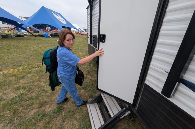 After receiving a military police escort to Division Hill, Tammy Widrick, Fort Drum FMWR financial management chief, secures the petty cash in a trailer for Mountainfest. (Photo by Mike Strasser, Fort Drum Garrison Public Affairs)