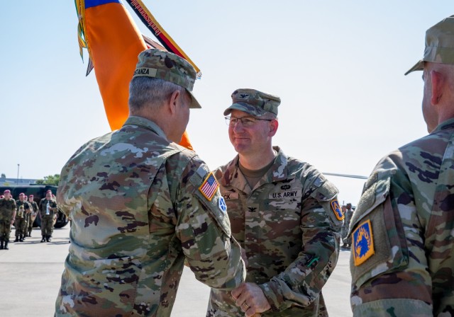 U.S. Army Lt. Gen. Charles Constanza, V Corps commanding general, passes the colors to Col. Adam Bock, incoming brigade commander of 12th Combat Aviation Brigade, during the change of command ceremony on Katterbach Army Airfield, Ansbach, Germany,...