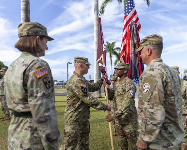 U.S. Army Col. William Bimson (center left), incoming commander, passes the unit colors to U.S. Army Command Sgt. Maj. Omar J. Bond, during the change of command ceremony for Tripler Army Medical Center, June 30, 2025.