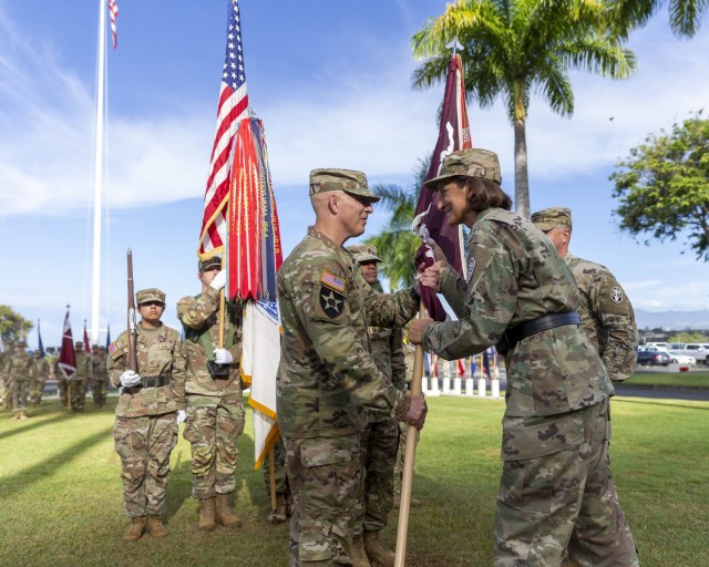 U.S. Army Brig. Gen. Deydre Teyhen (right), commanding general, Medical Readiness Command, Pacific, and director, Defense Health Network Indo-Pacific, passes the unit colors to U.S. Army Col. William Bimson, incoming commander, during the change...
