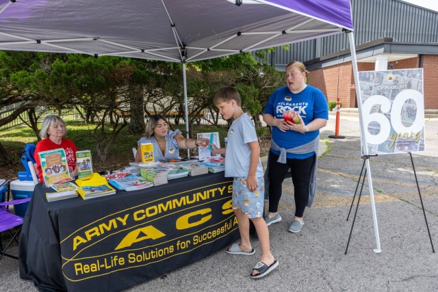 Army Community Service staff members celebrate the program’s 60th birthday at Fort Knox, Kentucky, July 7, 2025. The early celebration featured free children’s books and popsicles as well as information on ACS resources. The ACS program’s...