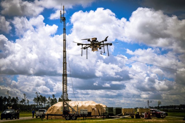 A tethered drone flies in a training site.