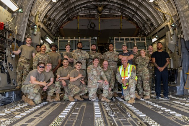 Soldiers from the 1st Battalion, 14th Field Artillery Regiment (1-14th FAR) pose with Maj. Gen. Winston Brooks (bottom right), the Fires Center of Excellence Commander, after completing Strategic Airlift (STRATAIR) operations at the Lawton...