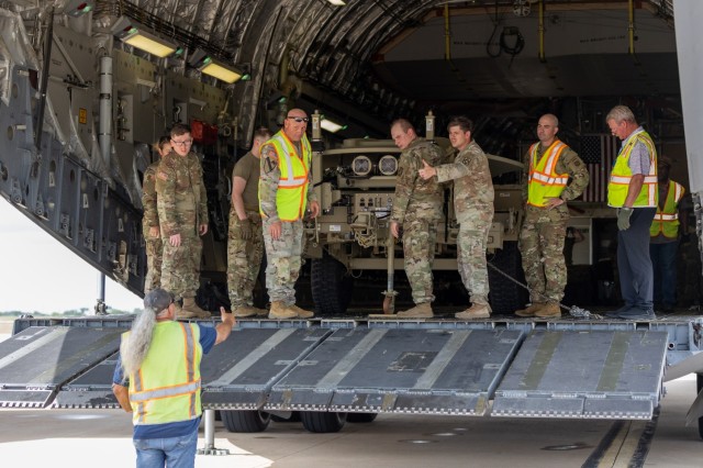 Maj. Gen. Winston Brooks (second from top left) and Soldiers from the 1st Battalion, 14th Field Artillery Regiment (1-14th FAR) load equipment and vehicles onto a C-17 aircraft as part of Strategic Airlift (STRATAIR) operations at the Lawton...