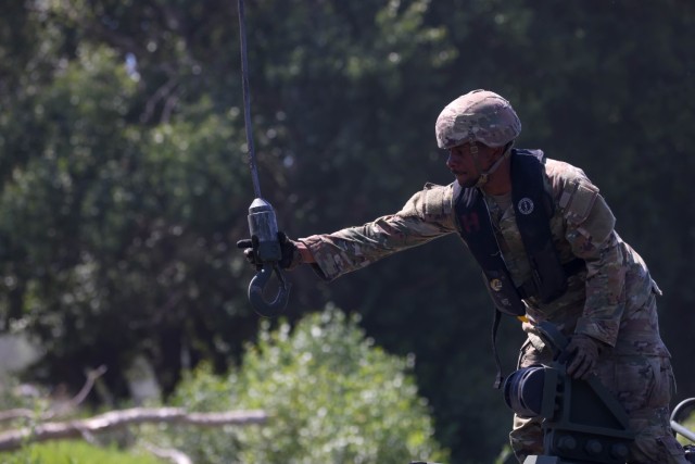 U.S. Army Sgt. Jalen Brown, 12C Boat Crew Member assigned to 809th Multi-Role Bridge Company, 7th Engineer Brigade, 21st Theater Sustainment Command, grabs a hook to secure and lift the M30 Bridge Erection Boat out of the water during wet gap...