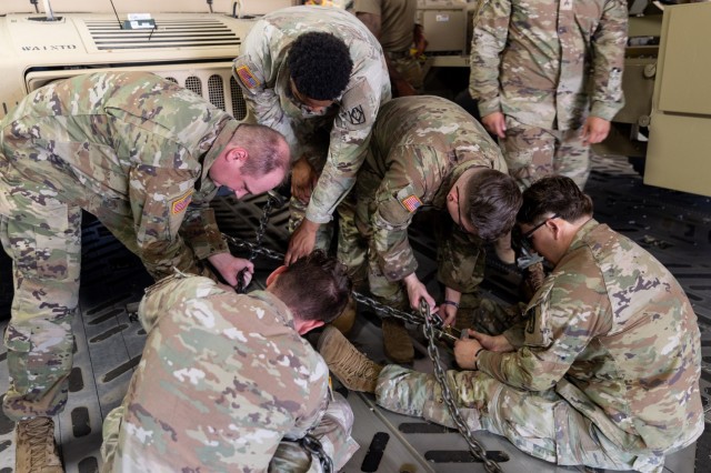 Soldiers from the 1st Battalion, 14th Field Artillery Regiment (1-14th FAR) secure a HMMWV after loading it onto a C-17 as part of Strategic Airlift (STRATAIR) operations at the Lawton Regional Airport June 30, 2025. 1-14th FAR deployed to Europe...
