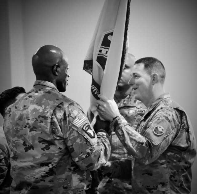Col. Steven L. Chadwick, the Fort Irwin Garrison Commander passes the unit colors to Command Sgt. Maj. DeMarius M. Lyles 10 July, 2025 as he assumes responsibility as the Fort Irwin Garrison Command Sgt. Maj. during a ceremony held at the Sandy...
