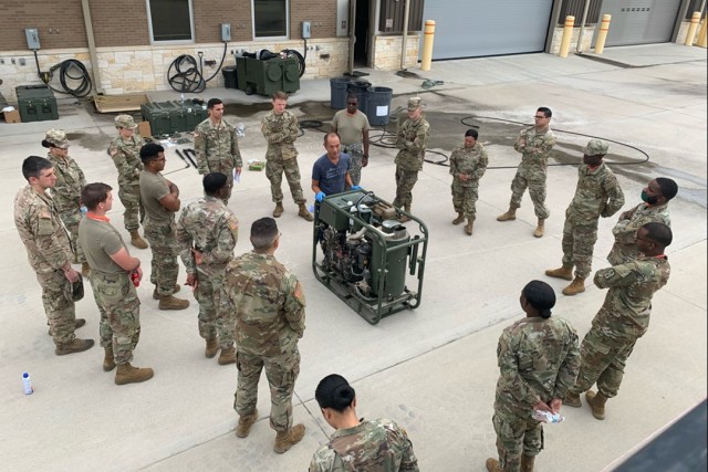Tuan Nguyen, DEVCOM CBC Electrical Engineer, provides hands on familiarization on the M26 Joint Service Transportable Decontaminating System, Small Scale, with Soldiers during an EAU assessment. (U.S. Army photo.)
