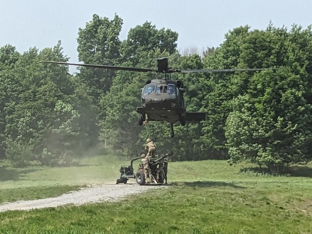 A UH-60M Black Hawk helicopter assigned to the New York National Guard's A Company, 3rd Battalion, 142nd Aviation, prepares to lift an M-119 howitzer belonging to the 1st Battalion, 258th Field Artillery during a training exercise at Fort...