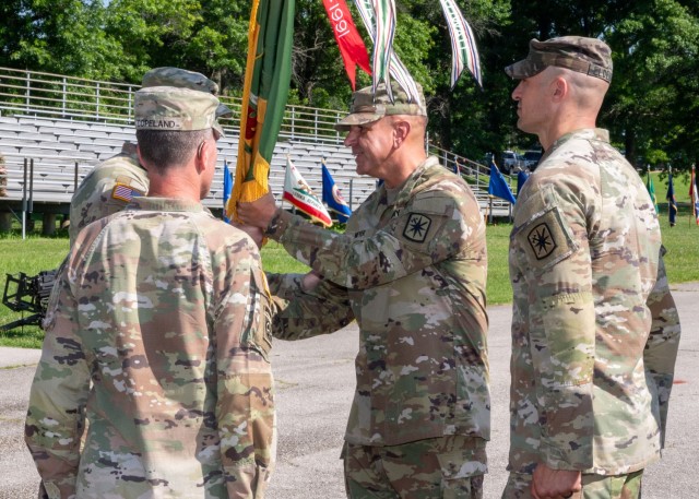 14th Military Police Brigade Commander Col. Samuel Meyer, officially accepts command by taking the brigade’s flag during a change-of-command ceremony July 11 on Gammon Field.