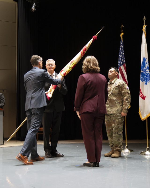 Scott Halter passes the garrison flag to William Cole during the garrison change of responsibility ceremony at the Detroit Arsenal July. 17.