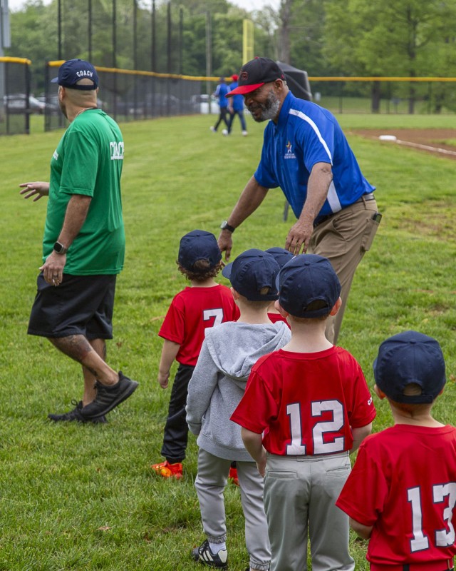 Jerry Arrington, director Fort Belvoir Child and Youth Sports, guides the youngest Little League players into place for the season&#39;s Opening Day, April 26.