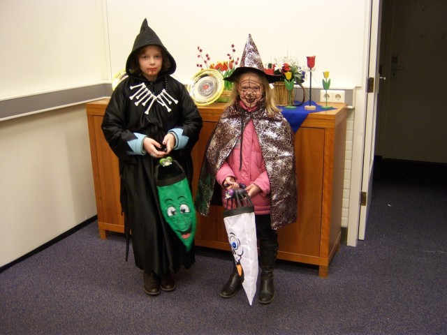 Two girls dressed on Halloween costumes pose for photo