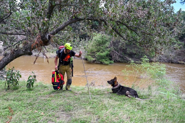 Matej Bartosik, a search and rescue dog handler with a Czech Republic emergency response team, or CZERT, works alongside his search-and-rescue dog Bart during flood response operations near Sisterdale, Texas, July 18, 2025. The Czech team...