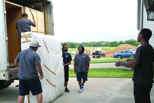 Staff Sergeant Cornel Varnado Jr., 194th Military Police Company, 716th Military Police Battalion, signs for packages as movers deliver household goods to his home at Fort Campbell, Ky. May 9, 2022. The Permanent Change of Station Joint Task...