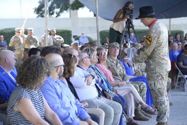 Right, 1st Lt. Austin Yoakum, member of the Salute Battery for the Fort Hood redesignation ceremony, 1st Cavalry Division Artillery, presents a 75mm round to Mitzi Huffman, daughter of Col. Robert B. Hood, during the ceremony July 28 at III...