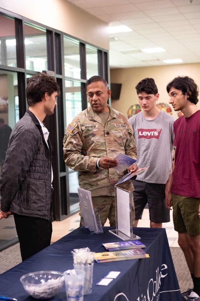 From left, Chase Buckelew, student success coach for Columbia College at Redstone Arsenal, shares details with Fox Army Health Center Commander Lt. Col. Deepak Mathew, Akshay Mathew and Manish Mathew.