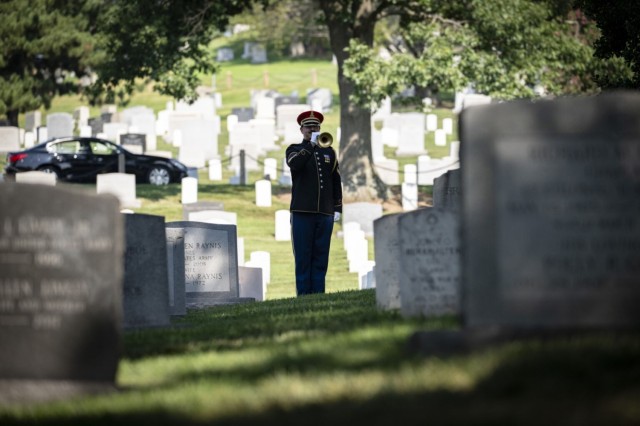 A bugler from the U.S. Army Band, &#34;Pershing&#39;s Own,&#34; plays &#34;Taps&#34; during a wreath-laying ceremony at Chaplains Hill at Arlington National Cemetery in Arlington, Va., July 25, 2025. The ceremony was one of three events that ANC...
