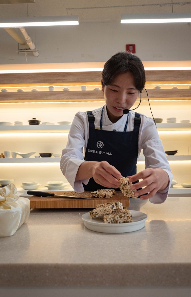 Seung An Oh, an instructor at the Hansik Space E:EUM, a place dedicated to teaching visitors about Korean culture and food, teaches U.S. Army Soldiers how to make Korean pop rice snacks in Seoul, July 31, 2025. Soldiers serving at Camp Casey...