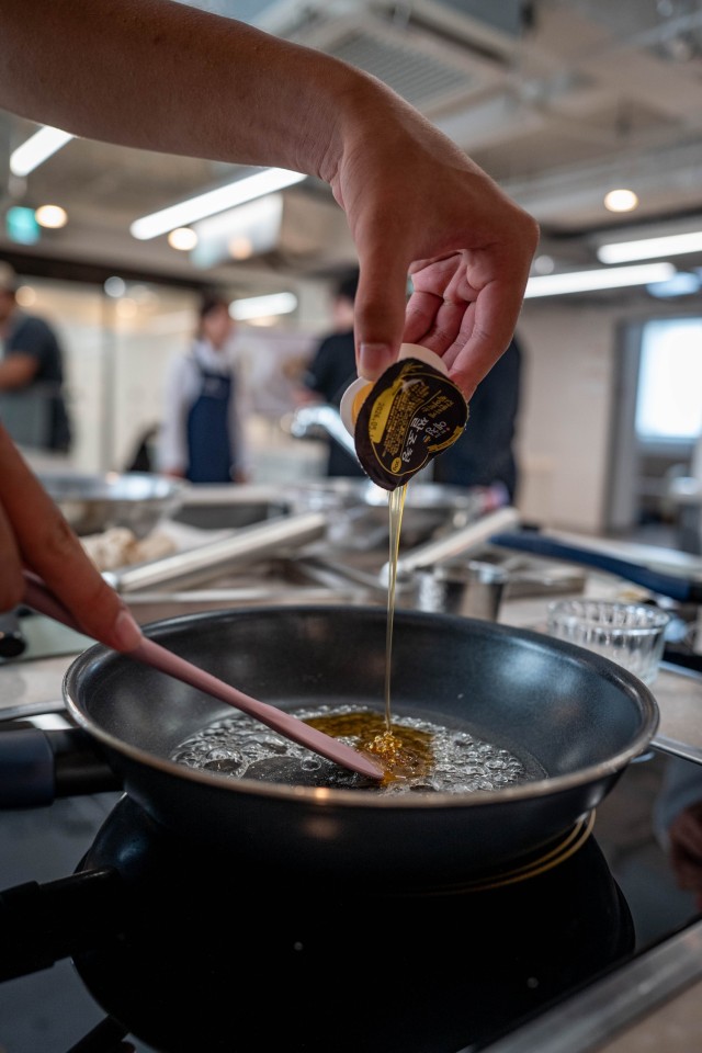Korean Augmentation to the United States Army (KATUSA) Cpl. Ju Won Kim, prepares Korean pop rice snacks at the Hansik Space E:EUM, a place dedicated to teaching visitors about Korean culture and food, in Seoul, July 31, 2025. Soldiers serving at...