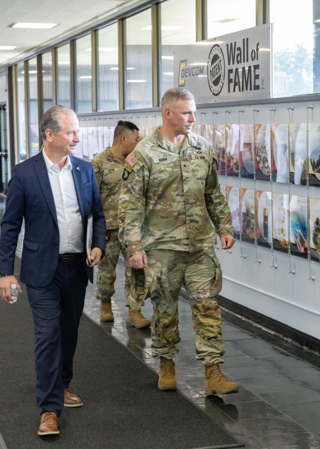 PICATINNY ARSENAL, N.J. - Chris Grassano, Director, U.S. Army Combat Capabilities Development Command (DEVCOM) Armaments Center (left), and Brig. Gen. Robert Born, DEVCOM Commanding General, (right) review the Armaments Center&#39;s Patent Wall of...