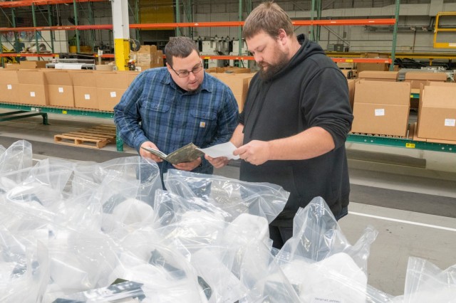 Bill Brothers (left) and Travis Stevens (right), members of the Tobyhanna Army Depot Logistics Management team, ensure all antenna mount kits are accounted for as part of the HMS radio “A-Kit” platform integration effort.