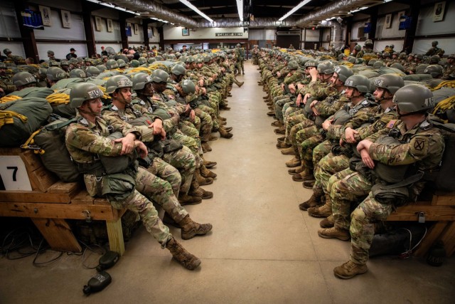 U.S. Army Soldiers, Sailors, Airmen and Marines attached to Charlie Company, 1st Battalion, 507th Parachute Infantry Regiment, rig up with T-11 parachutes before boarding a C-17 cargo aircraft to successfully conduct a static line jump during jump...