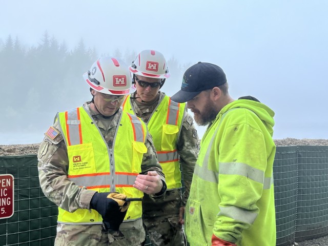 Brig. Gen. Joseph C. “Clete” Goetz and Command Sgt. Maj. Zachary Plummer discuss street flood mitigation and response efforts with City and Borough of Juneau employee