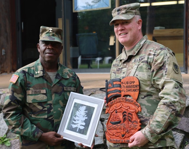 Armed Forces of Liberia (AFL) Maj. Urias Zogga, AFL chaplain general, left, and U.S. Army Col. Brian Martinus, Michigan National Guard State Chaplain, conduct a gift exchange at Camp Grayling Joint Maneuver Training Center, Michigan, June 13,...