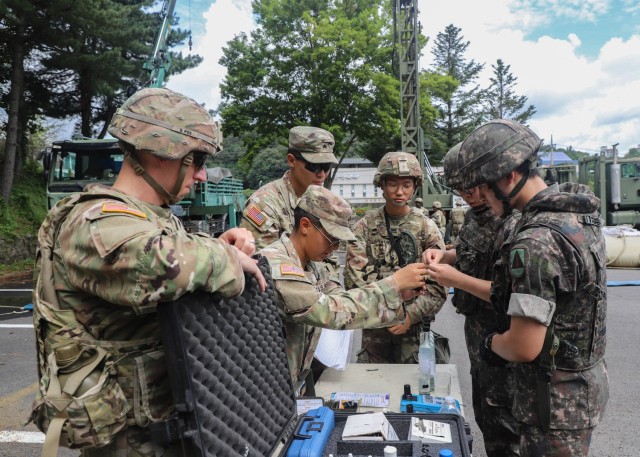 Pfc. Honie Garcia, a water treatment specialist assigned to 194th Division Sustainment Support Battalion, Sustainment Brigade, 2nd Infantry Division/ROK-U.S. Combined Division, shows Cpl. Beom-gi Lee, a signalman, and Pvt. Tae-woo Kim, a combat...