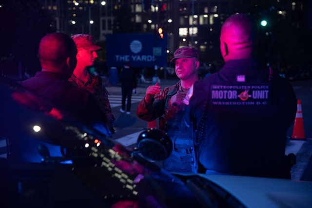 Army 2nd Lt. Harry Siegel and Sgt. 1st Class Nikolay Bashko talk with D.C. Metropolitan Police Department officers near Nationals Park in Washington, Aug. 19, 2025. National Guardsmen were activated under the D.C. Safe and Beautiful Task Force,...