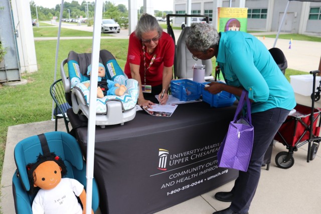Nurse Kelly Petee, from Community Outreach and Health Improvement, University of Maryland Upper Chesapeake Health, speaks to an attendee about car seat safety at APG North Safety Day on August 13, 2025.