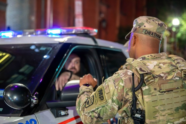 Army Maj. Eric Cheatham, assigned to the Tennessee Army National Guard, speaks with local authorities in Washington, Aug. 24, 2025. About 2,000 National Guard members are supporting the D.C. Safe and Beautiful Task Force, Joint Task Force District...