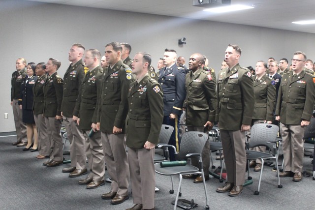 Graduates sing The Army Song at the conclusion of their graduation in the auditorium of the Command and General Staff School, Redstone campus.