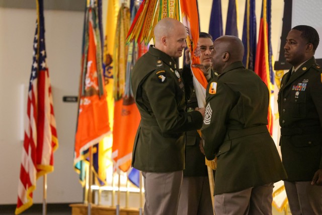 Outgoing 21st Theater Signal Brigade Command Sgt. Maj. Thomas Bray passes the colors to Brigade Commander, Col. John Sanders, during the change of responsibility ceremony on Ft. Detrick, Friday, Sept. 5, 2025.