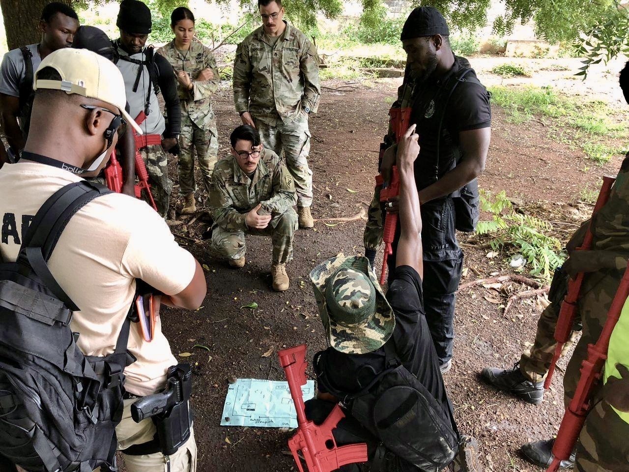 U.S. Army civil affairs Soldiers assigned to Bravo Company, Civil Affairs Battalion, U.S. Army Southern European Task Force, Africa (SETAF-AF) and members of Côte d’Ivoire’s national assault police unit, known as Force de Recherche et d'Assaut de la Police, discuss the outcomes from the close-quarters battle training in Korhogo, Cote d'Ivoire, July 14, 2025. The exchange provided the civil affairs team with a greater understanding of the unit's tactical procedures and capabilities, strengthening the relationship between the two units. (U.S. Army courtesy photo)