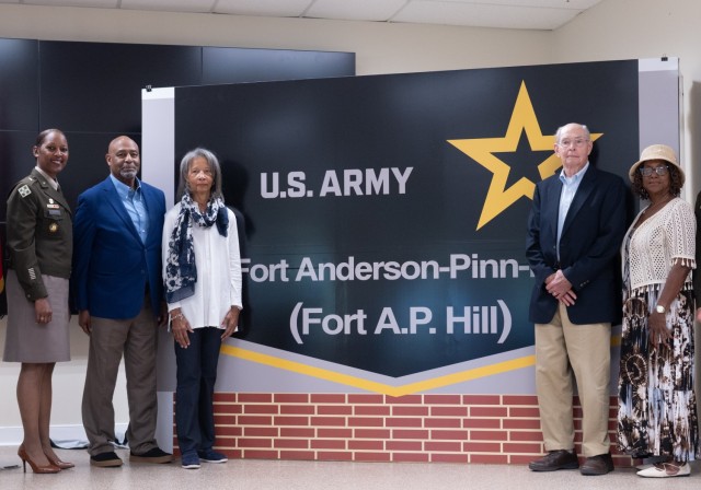 Families stand with BG Gant in front of the replica installation sign.