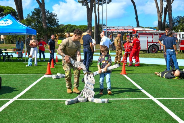 In commemoration of the 9/11/2001 attacks, the USAG-Italy Fire Department hosted a public Firefighter Challenge. This event includes a series of physical challenges, including a charged hose pull, a dummy drag, a Keiser sled, and a tire flip. The...