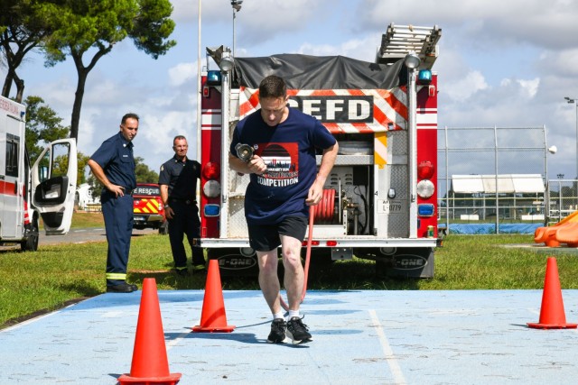 In commemoration of the 9/11/2001 attacks, the USAG-Italy Fire Department hosted a public Firefighter Challenge. This event includes a series of physical challenges, including a charged hose pull, a dummy drag, a Keiser sled, and a tire flip. The...