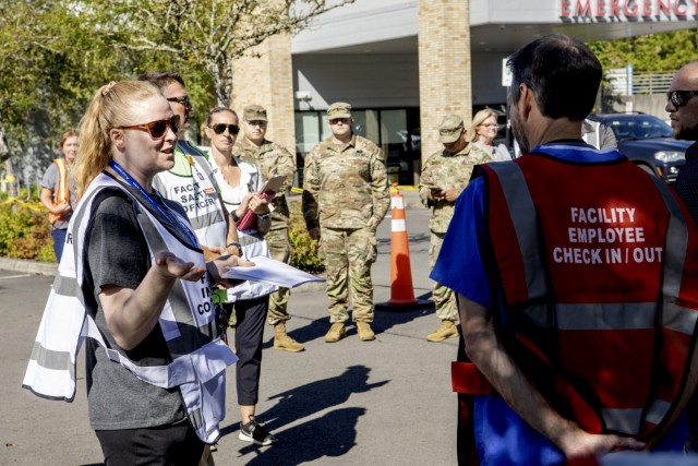 Mercedes Burley, an emergency medical nurse and member of the Emergency Preparedness Committee for Kaiser Permanente Sunnyside Medical Center, gives a briefing on the training objectives with decontamination procedures to the Sunnyside Medical Center staff as part of a simulated mass casualty event at the medical center on September 16, 2025, in Clackamas, Oregon. The Sunnyside Medical Center medical personnel and other first responders, along with members of the Oregon National Guard 102nd Chemical Biological Radiological Nuclear (CBRN) Defense Enhanced Response Force Package (CERFP), collaborated during the exercise, which aimed to develop a response to a real-world incident, identify gaps, and improve response procedures. 