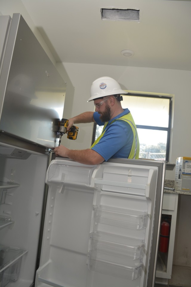 Caleb Ausbrooks, an installation specialist with Brownell Enterprises installs a new refrigerator in a home in Allen Heights. The renovations include all new stainless steel kitchen appliances.