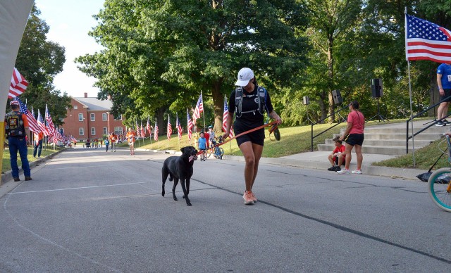 Staff Sgt. Rosemary Gonzalez encourages her dog Knucke to keep going as they finish the Run/Walk for the Fallen Sept. 13, 2025, by the Resiliency Center at Fort Leavenworth, Kansas. Photo by Emilio Gutierrez/Fort Leavenworth Lamp Intern