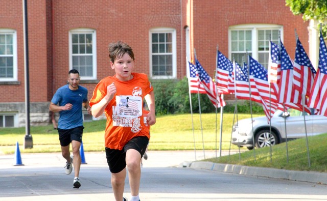 Nine-year-old Evan Douglass, followed by Capt. Kunal Shrungarkar, runs as fast as he can to finish the Run/Walk for the Fallen Sept. 12, 2025, by the Resiliency Center at Fort Leavenworth, Kansas. Participants wore bibs bearing the names of fallen...