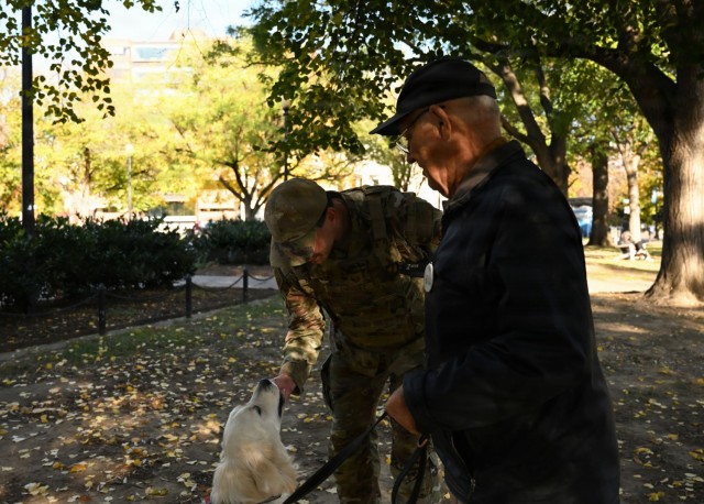U.S. Air Force Tech. Sgt. Andrew Enriquez, a public affairs specialist with the 113th Wing, District of Columbia Air National Guard, interacts with a local resident and his dog, Bailey, during a presence patrol in Dupont Circle, Washington, D.C.,...