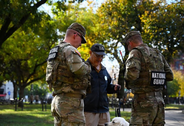 U.S. Army Pfc. Daniel Tippett and Spc. Ayden Holbert interact with a local resident and his dog, Bailey, during a presence patrol in Dupont Circle, Washington, D.C., Nov. 3, 2025. About 2,400 National Guard members support the D.C. Safe and...