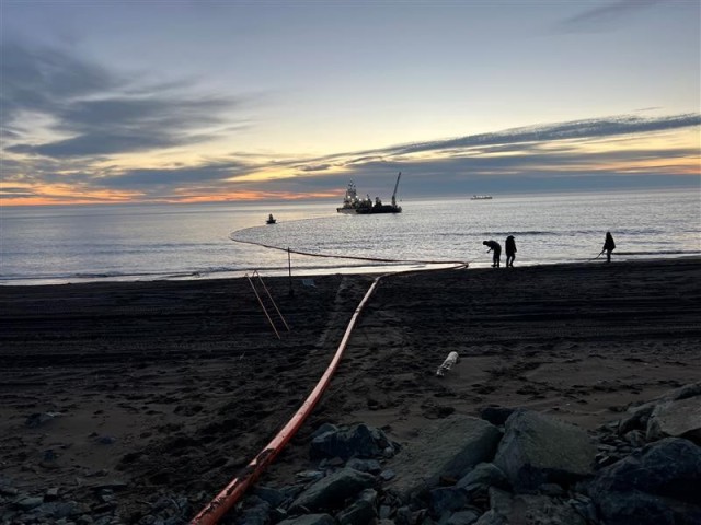 Pilot boat and crew deploying the floatable hose at Point Lay, Alaska, to begin discharging fuel over-the-shore.