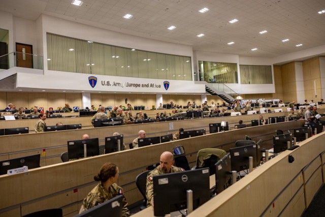 Service members from several NATO nations conduct simulated mission analysis inside...