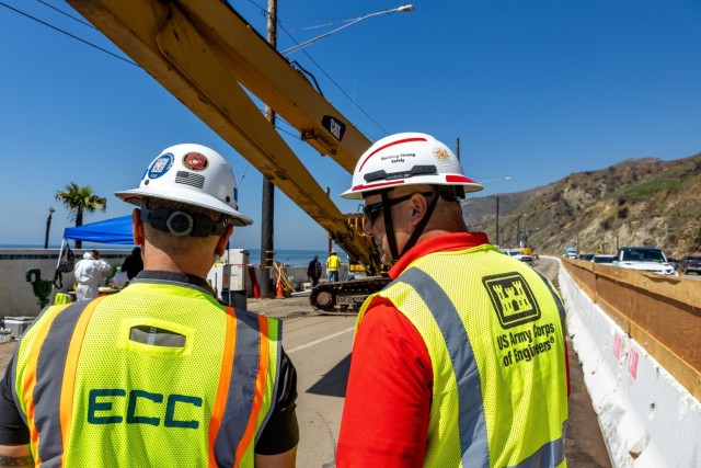 Joey Gibbs, safety officer with the U.S. Army Corps of Engineers Emergency Field Office — Pacific Palisades, speaks with a contractor as debris removal continues along Pacific Coast Highway in Malibu, April 9, 2025. ...
