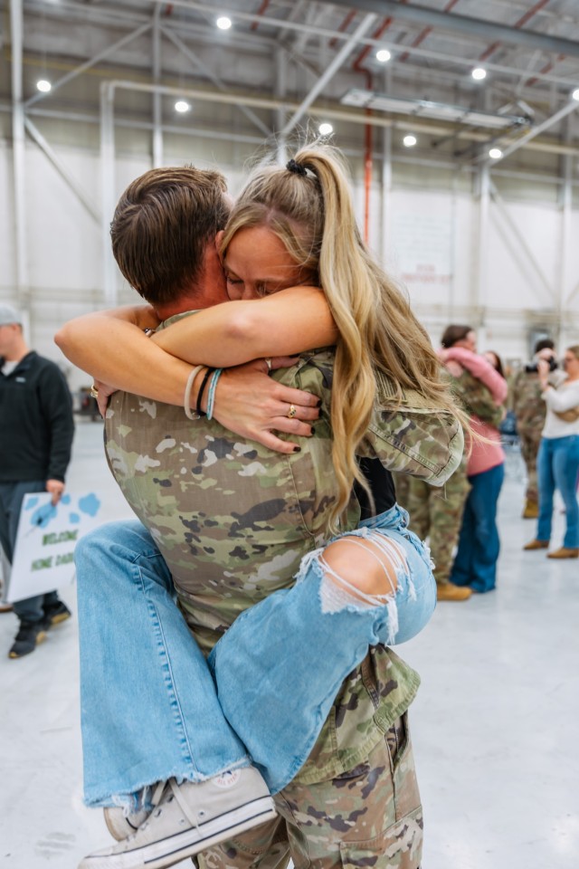 Cw2 Clark (RJ) Urban III  is embraced by his wife Mrs. Stevie Urban after returning from a 9-month deployment to the Horn of Africa with the 1st Battalion, 58th Aviation Regiment on Fort Rucker Nov. 19.
